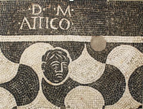 8.Frammento mosaico b/n figurato: motivo a squame con inserito un volto e iscrizione D M ATTICO, II sec. -inizi III sec. d.C.